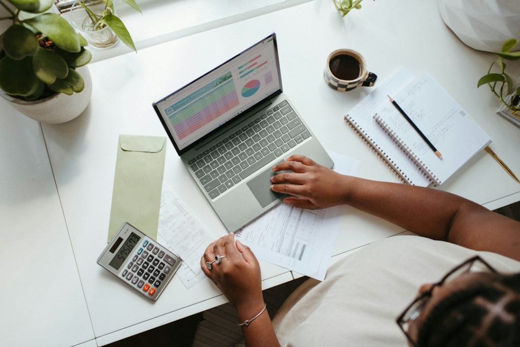 Seseorang merencanakan keuangan menggunakan laptop di meja kerja